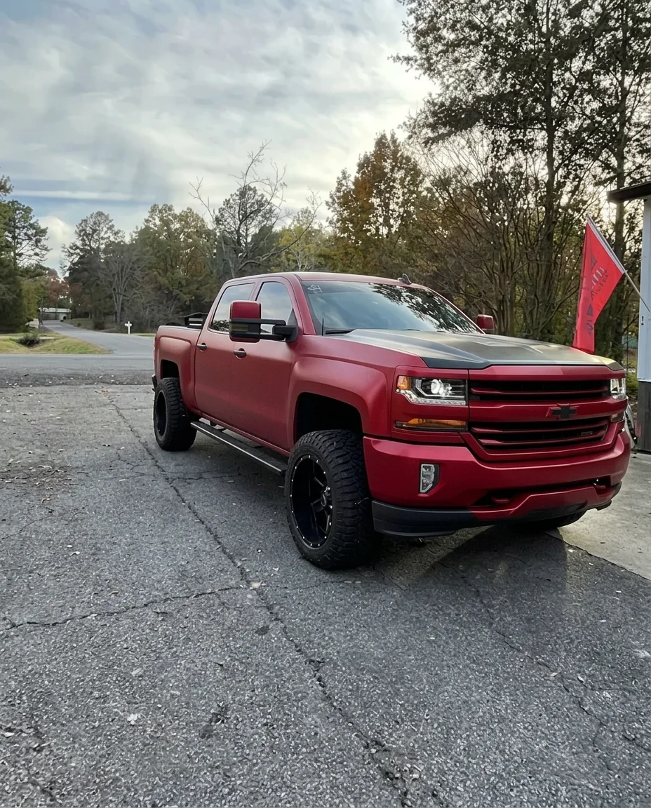 Satin red color change wrap on a lifted Chevy Silverado in Conway Arkansas